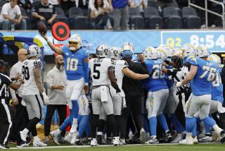 The Chargers' Justin Herbert (10) emerges after he was hit out of bounds by the Raiders' Jerry Tillery (90), who was ejected.