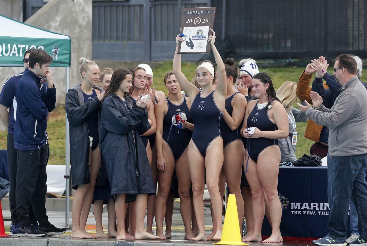 Flintridge Prep's Natalie Kaplanyan holds up the runner-up plaque after the Rebels lose 6-4 against Marina in the CIF Southern Section Division VI championship match at Woollett Aquatics Center in Irvine on Saturday.