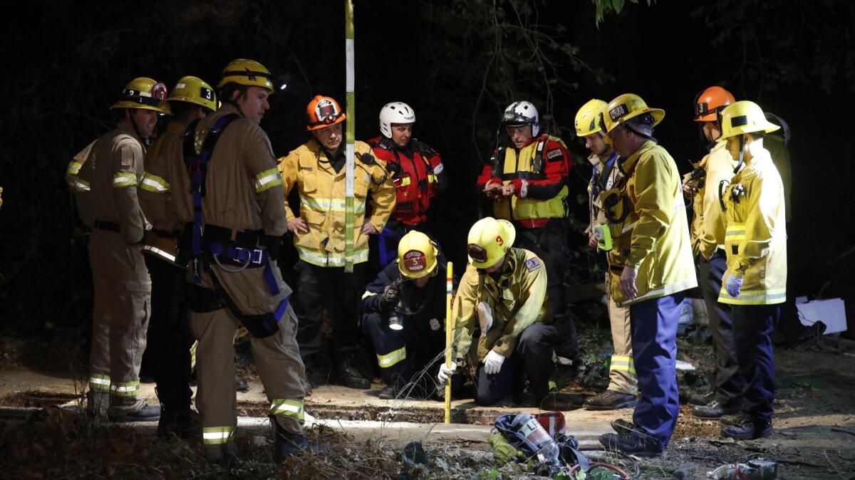 Firefighters search for a Jesse Hernandez, 13, in a hole near the Los Angeles River at the interchange of the 134 and 5 freeways on Sunday night.
