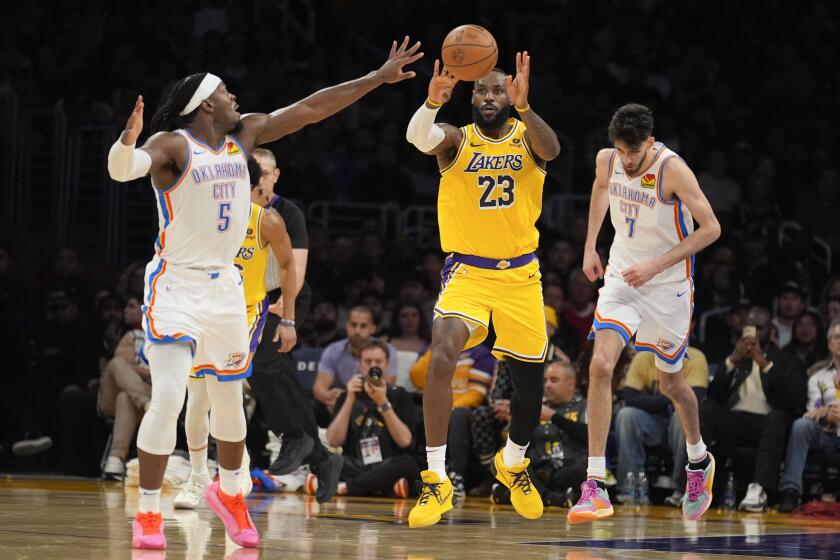 LeBron James (23), de los Lakers de Los Ángeles, pasa el balón sobre Luguentz Dort (5), del Thunder de Oklahoma City, durante la segunda mitad del juego de baloncesto de la NBA, el lunes 4 de marzo de 2024, en Los Ángeles. (AP Foto/Marcio Jose Sanchez)