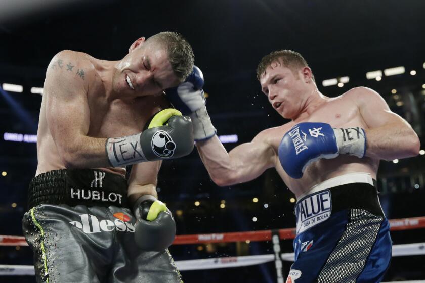 Canelo Alvarez, right, lands a right against Liam Smith during the ninth round of their fight on Sept. 17 at AT&T Stadium in Arlington, Texas.