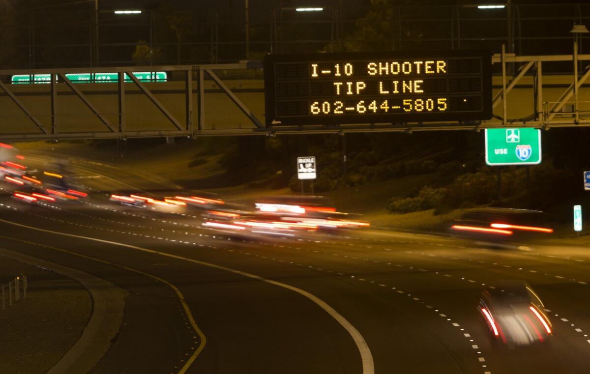 A sign above Interstate 10 in Phoenix calls on the public to help authorities catch whoever was responsible for a series of freeway shootings that have rattled residents in recent weeks.