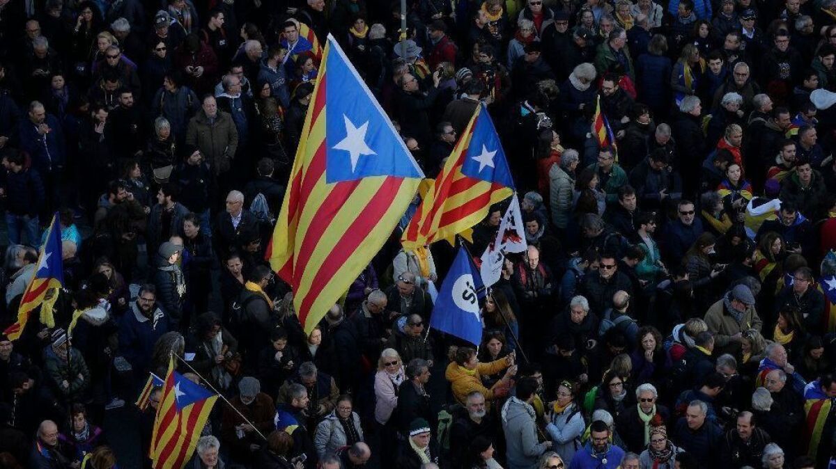 People, some with Catalonia independence flags, protest Spain's Cabinet holding a meeting in Barcelona on Dec. 21, 2018.