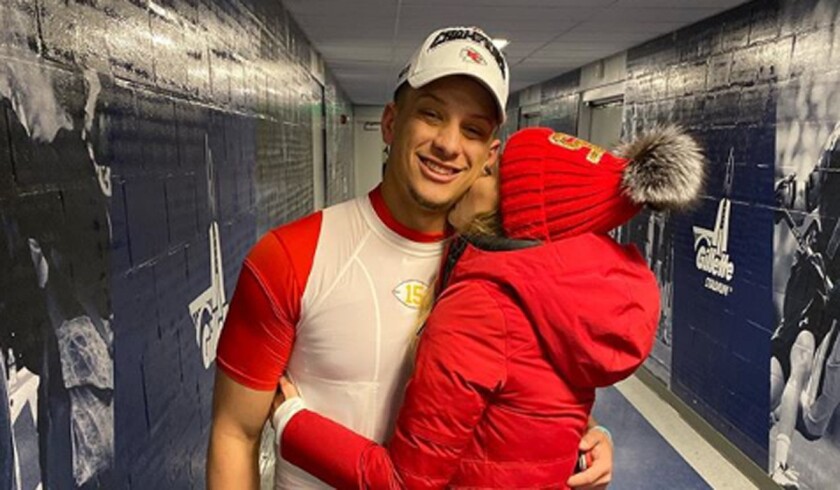 Brittany Matthews kisses Kansas City Chiefs quarterback Patrick Mahomes in a Gillette Stadium hallway.