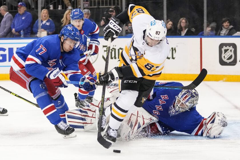 New York Rangers goaltender Igor Shesterkin, right, and Niko Mikkola, left, protect their net from Pittsburgh Penguins' Sidney Crosby (87) during the third period of an NHL hockey game, Saturday, March 18, 2023, in New York. The Rangers won 6-0. (AP Photo/Frank Franklin II)