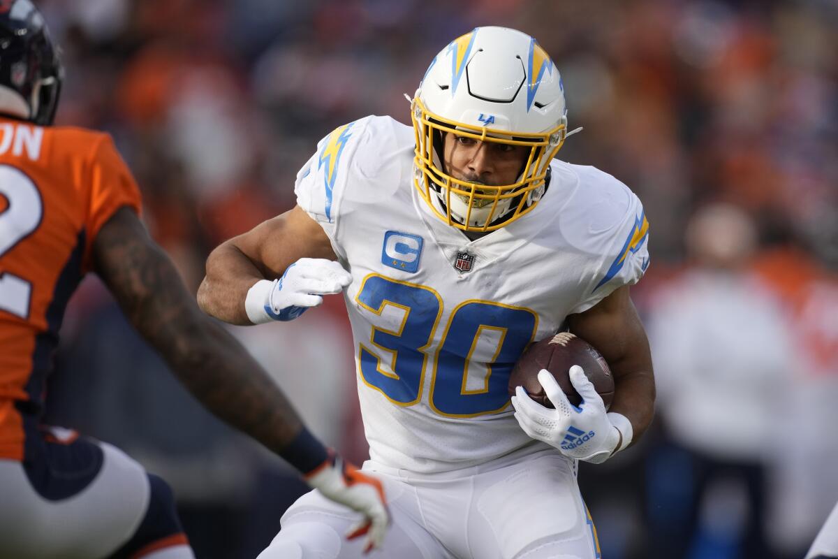 Chargers running back Austin Ekeler carries the ball against the Broncos in the first half.