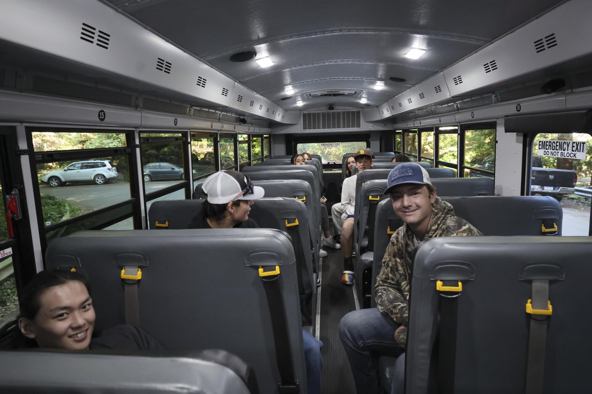 Teen students sit in a school bus.