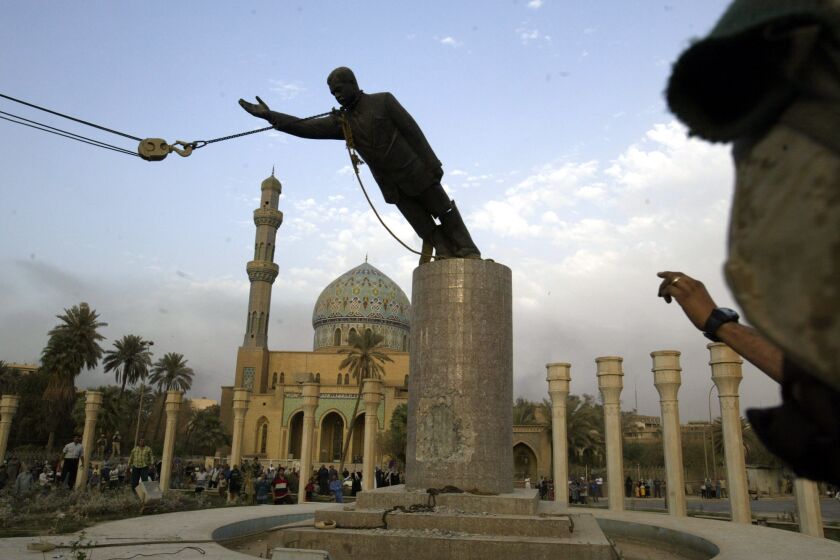 ARCHIVO - Un infante de marina estadounidense observa cómo se derriba una estatua de Saddam Hussein el miércoles 9 de abril de 2003 en el centro de Bagdhad. (AP Foto/Jerome Delay, Archivo)