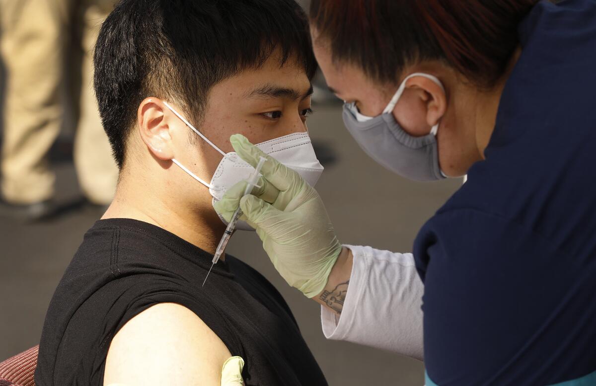 Changhun Sung receives a dose of the COVID-19 vaccine at a mobile clinic in Los Angeles. 