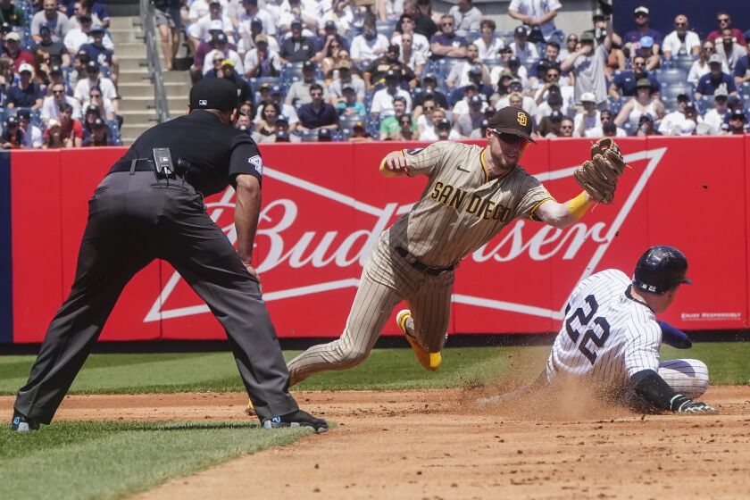 San Diego Padres' Jake Cronenworth, center, tags out New York Yankees' Harrison Bader, right, who was trying to steal second base during the fourth inning of a baseball game, Saturday, May 27, 2023, in New York. (AP Photo/Bebeto Matthews)