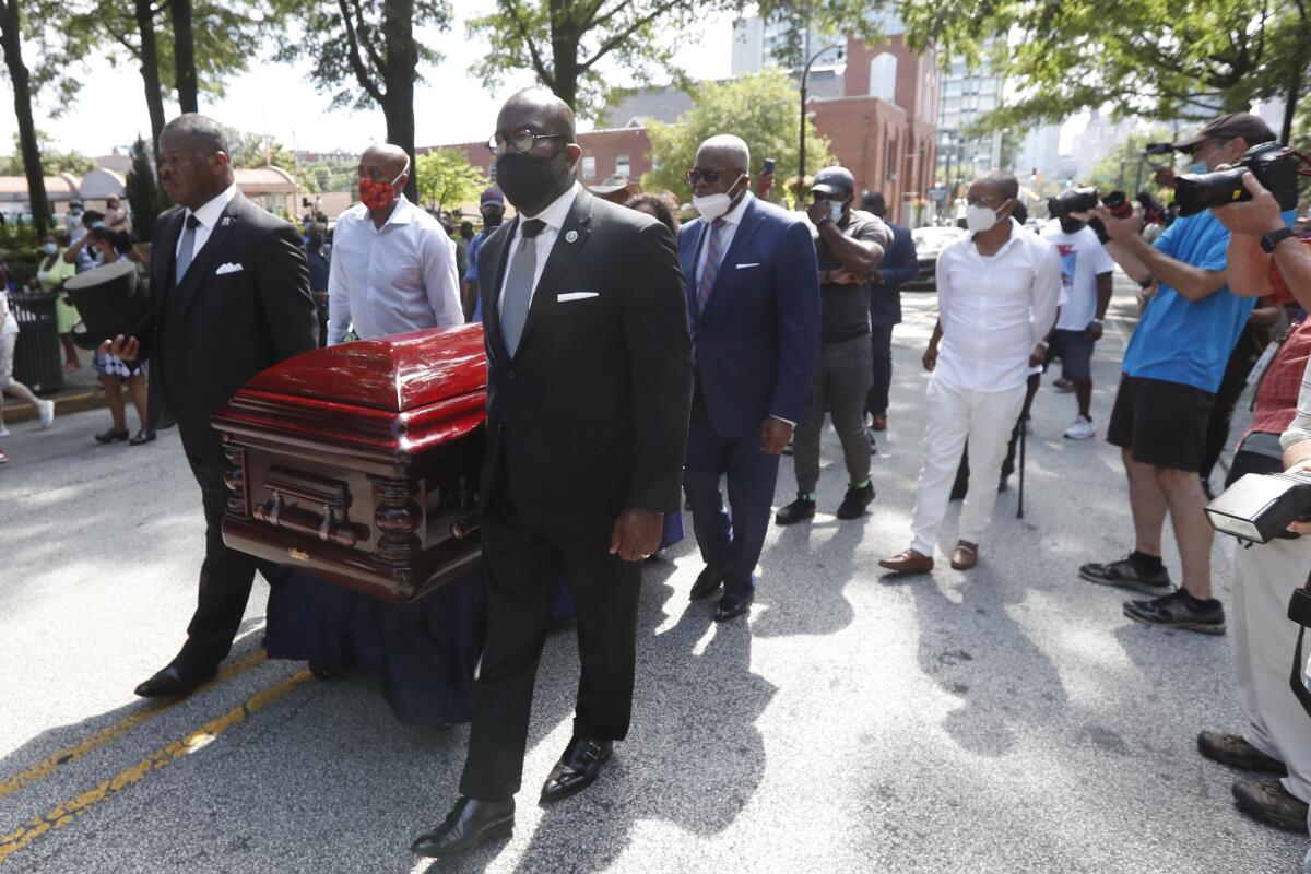 Mourners march with the casket of the Rev. C.T. Vivian in Atlanta