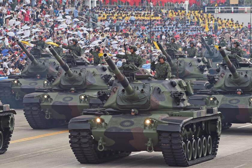 Soldiers salute from M60A3 tanks during a parade in Taiwan marking 70 years since the end of World War II at a military base in Hsinchu, northern Taiwan, on July 4.