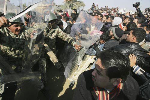 Egyptian border guards and riot police officers clash today with Palestinians trying to cross the border after militants exploded the wall between Gaza Strip and Egypt earlier this week.