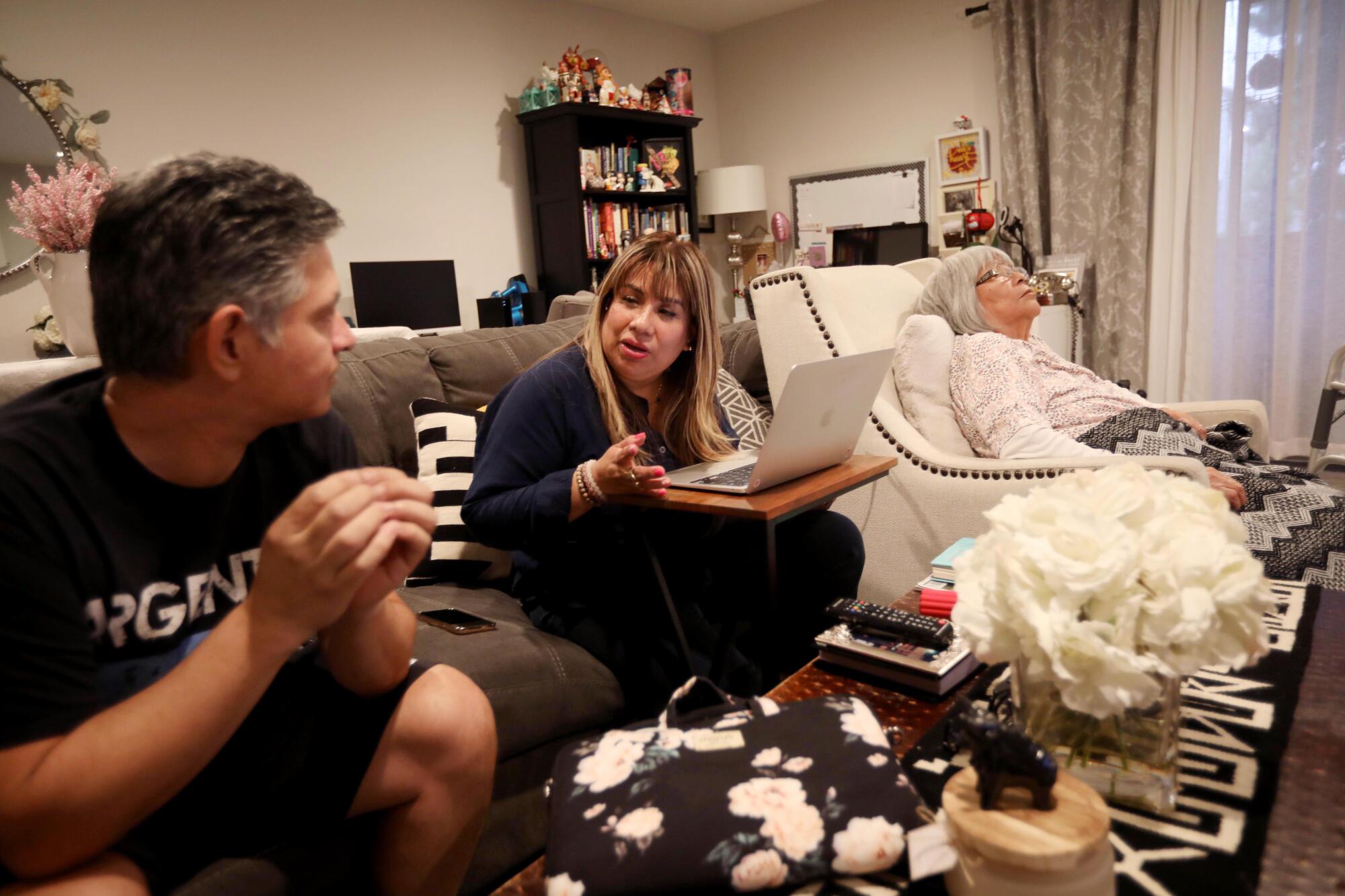 Mariella Rojas, center, talks with her husband, Julio, as her mother, Rosa Angelica Saldana, naps.