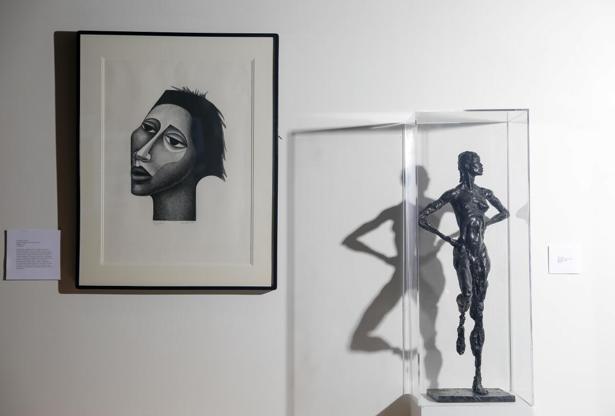 A hanging portrait and a sculpted figurine.
