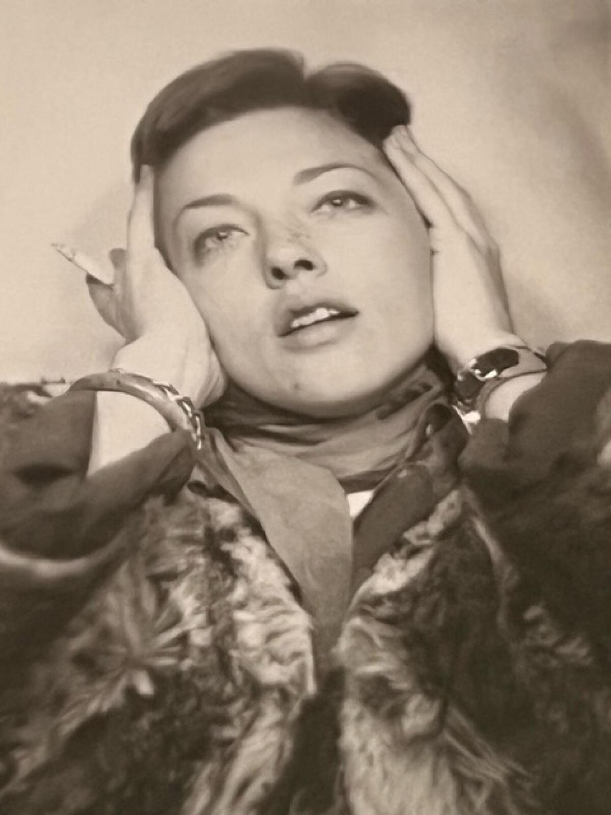 A sepia-toned photo of a woman looking upward, her hands on either side of her face.