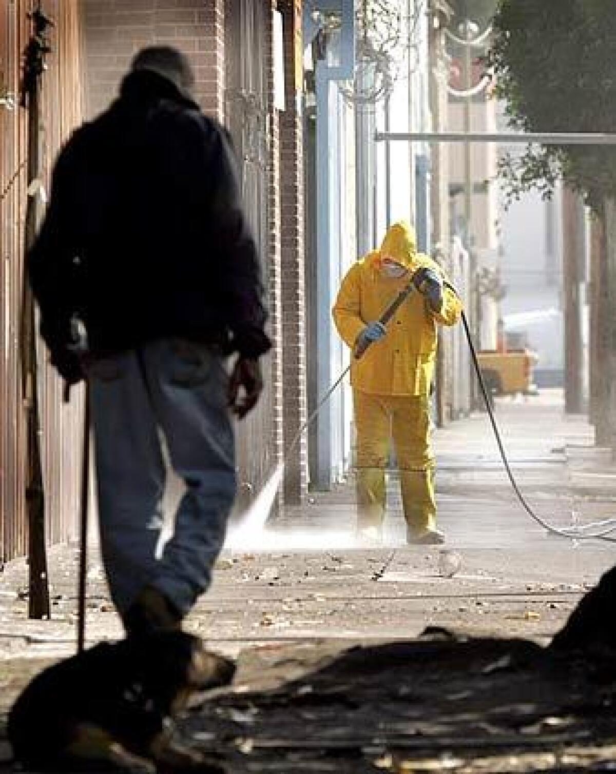 HIGH PRESSURE: A worker uses a washer to clean sidewalks on Gladys Street between 5th and 6th streets Tuesday morning, part of an effort by the Central City East Assn. to revitalize downtown.