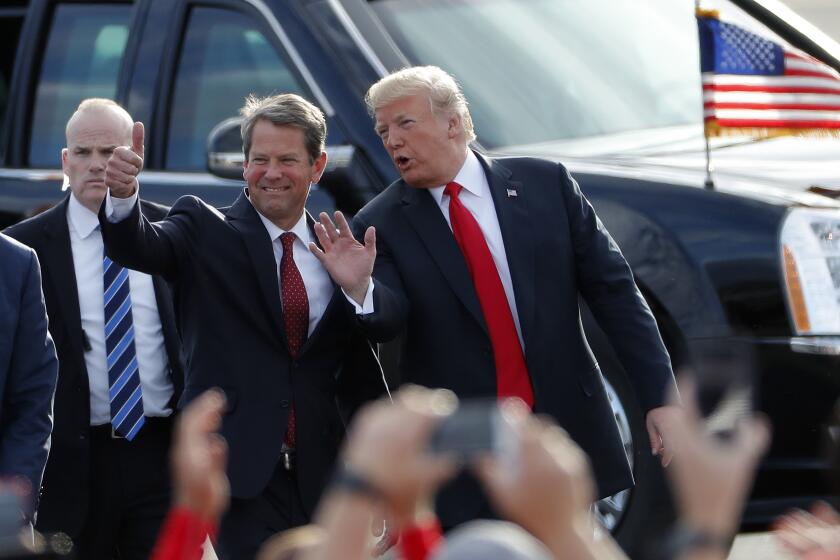 FILE - In this Nov. 4, 2018, file photo, then-Georgia Republican gubernatorial candidate Brian Kemp, left, walks with President Donald Trump as Trump arrives for a rally in Macon , Ga. President Trump said Sunday, Nov. 29, 2020 he was “ashamed” for endorsing the Republican governor of Georgia after he lost in the state to Democrat Joe Biden. Trump said on Fox News that Gov. Brian Kemp has “done absolutely nothing” to question the state’s results.. (AP Photo/John Bazemore, File)