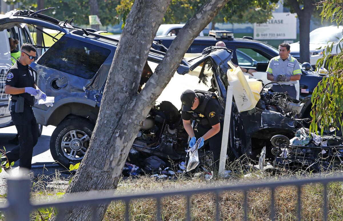 An Orange County Sheriff collects items from the wreckage of a fatal collision Friday on Newport Boulevard. 