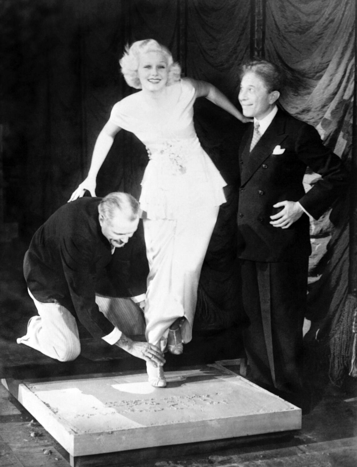 Sid Grauman, at right, takes Jean Harlow's footprint, at the Grauman's Chinese Theatre in Los Angeles, California, in 1933 (Gamma-Keystone via Getty Images)