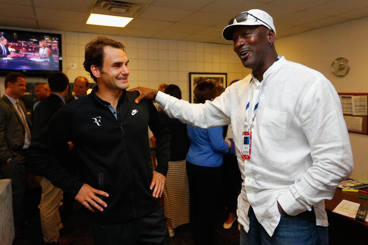 Tennis star Roger Federer and NBA Hall of Famer Michael Jordan meet following a U.S. Open tennis match Tuesday.