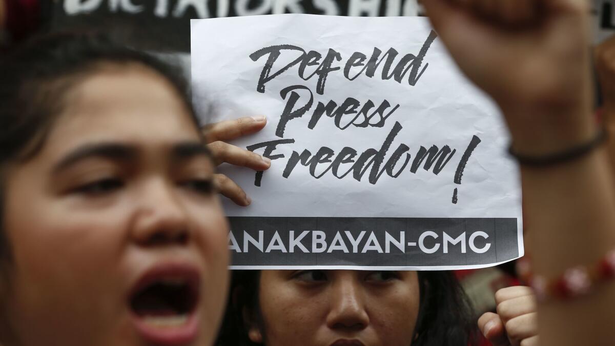 A protester holds a sign at a demonstration at the University of the Philippines in Quezon City on Tuesday.