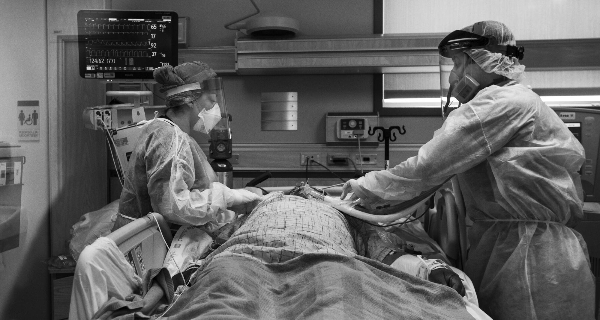 Nurse Griselda Llanos, left, and Dr. Anthony Arredondo work on a COVID-19 patient.