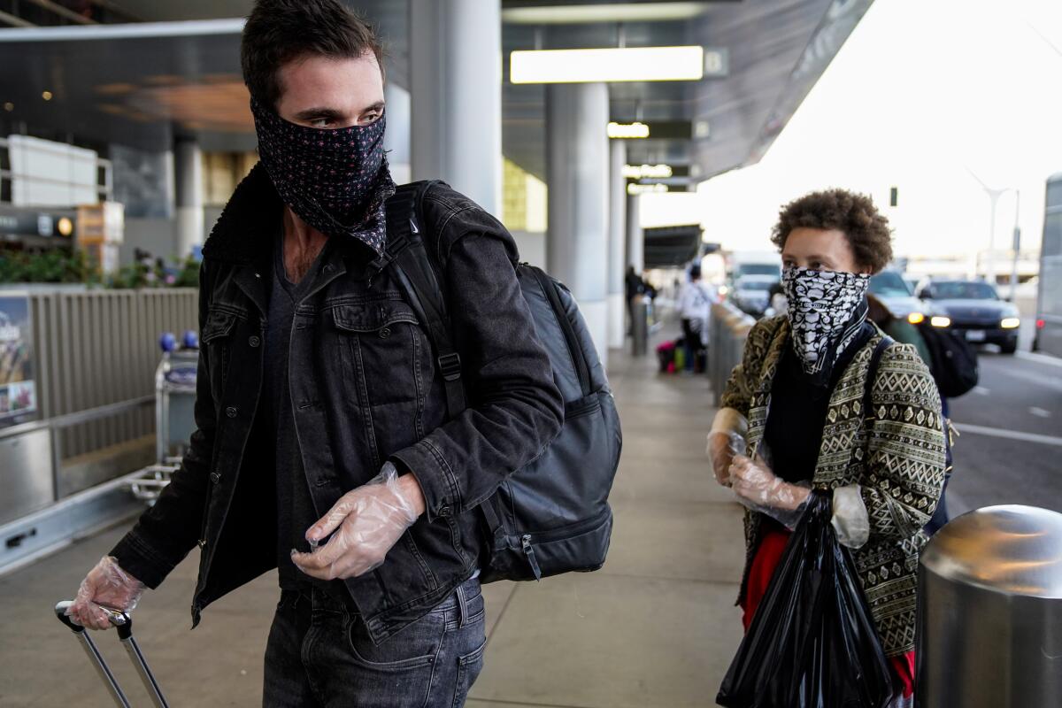 Travelers wearing masks at Los Angeles International Airport