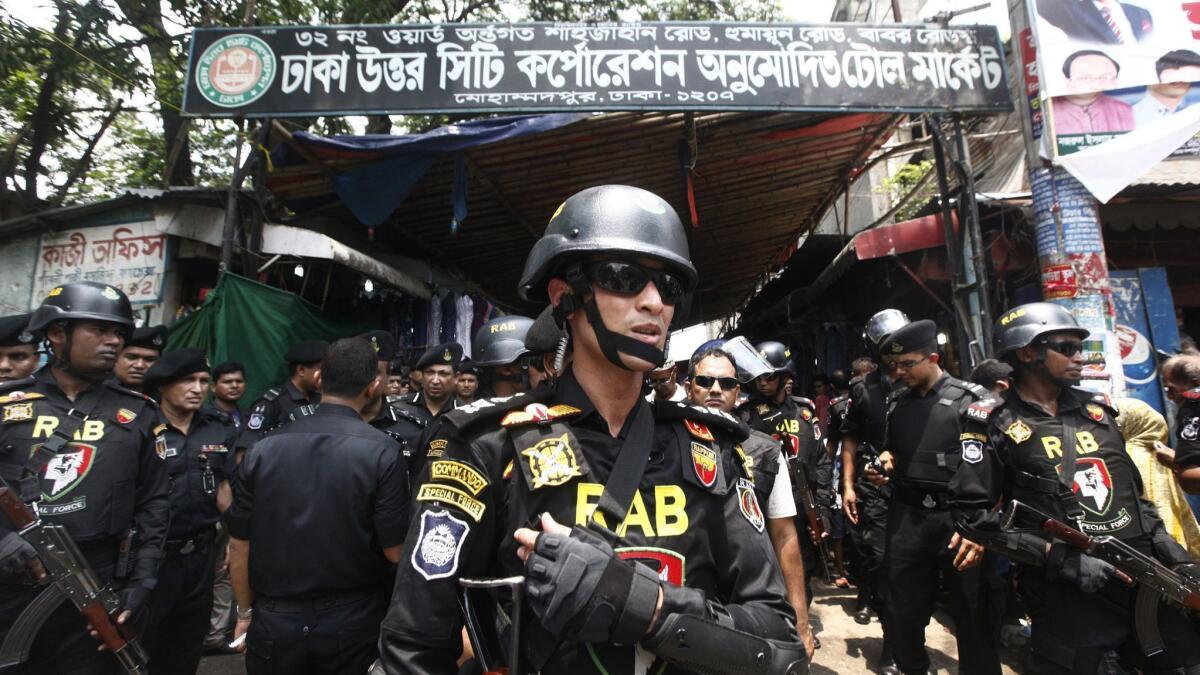 Bangladesh's Rapid Action Battalion (RAB) soldiers stand guard during a raid on suspected drug dealers at Geneva Camp in Dhaka on May 26, 2018.