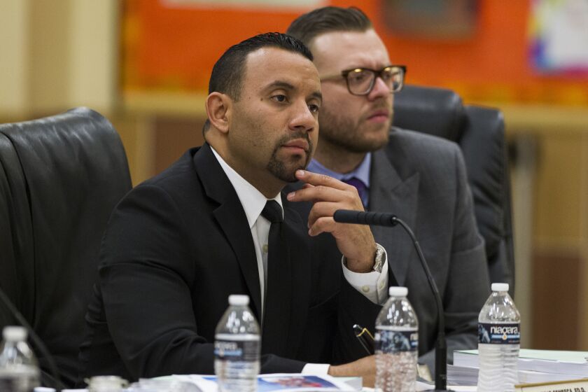 Superintendent Julio Fonseca, left, and Arturo Sanchez-Macias, chief business officer of the San Ysidro School District, listen to a presentation at the Feb. 9 school board meeting at Sunset Elementary School.