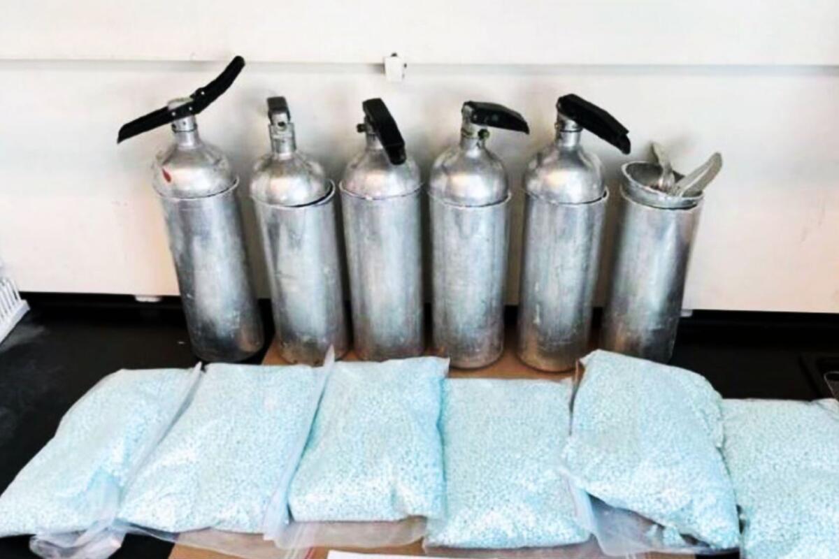 Bags of drugs are in front of canisters.