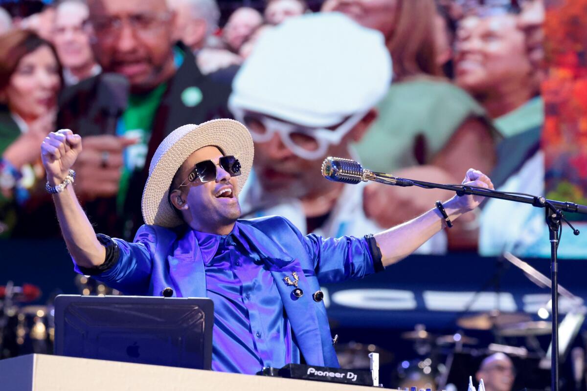  DJ Cassidy gestures before a microphone at the convention 