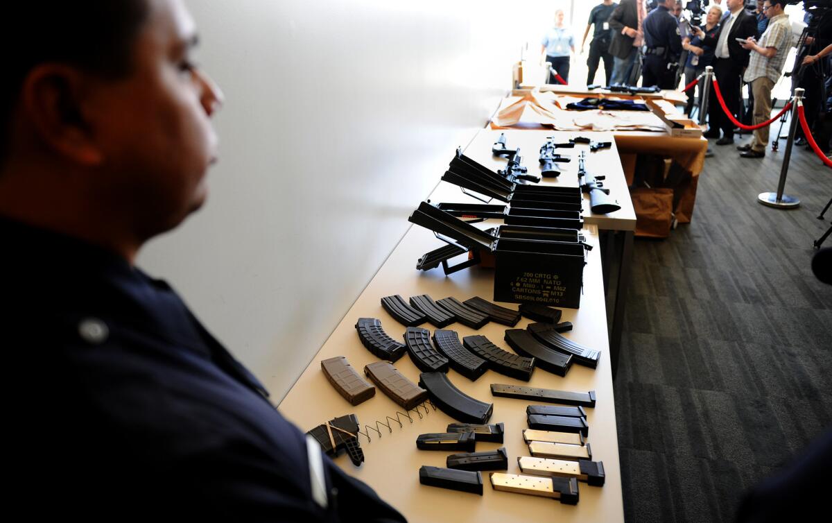 An officer stands by a cache of weapons found in Daniel Yealu's apartment.