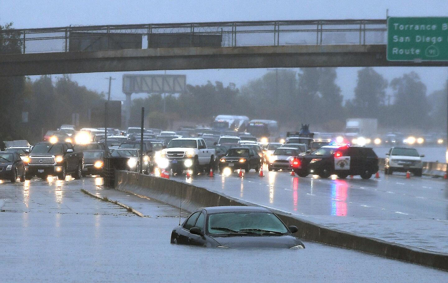 A car is stuck in standing water on the southbound 110 Freeway on Jan. 22.