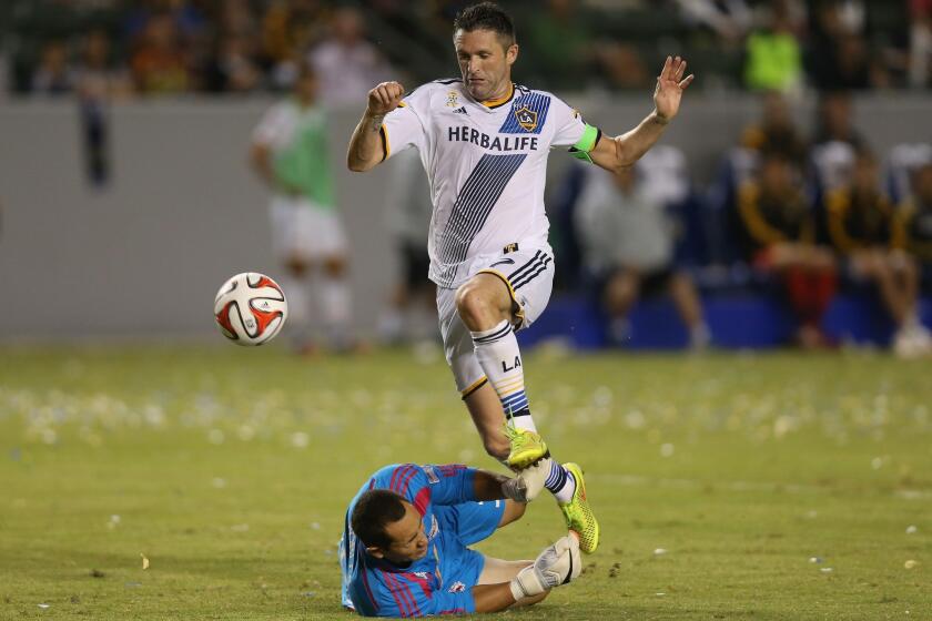 New York Red Buills goal keeper Luis Robles makes a save on the Galaxy's Robbie Keane during a match on Sept. 28.