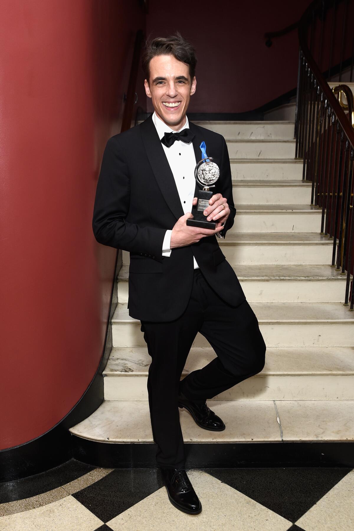 Steven Levenson in a tuxedo, holding his Tony Award.