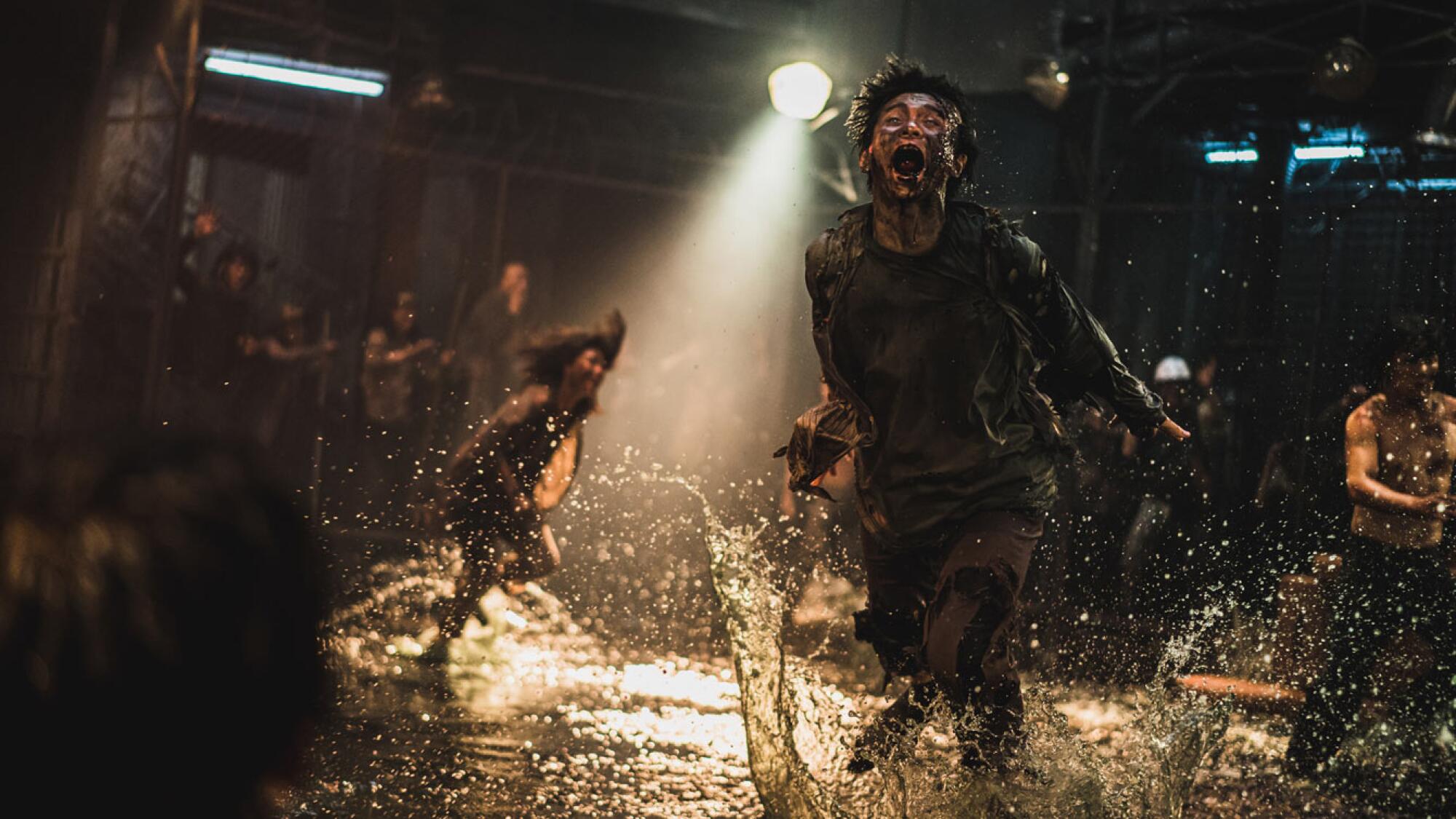 A zombie screams in a puddle of water in a scene from the movie Peninsula
