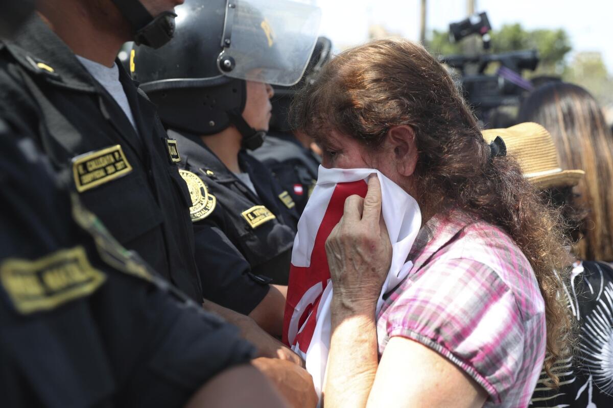 A supporter of former Peruvian President Alan Garcia cries as she learns of his death outside the Lima hospital where he was treated.