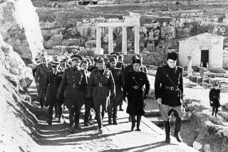 ARCHIVO - El dictador italiano Benito Mussolini, al centro, y el mariscal Italo Balbo, gobernador de Libia, izquierda, inspeccionan las excavaciones de los restos históricos en Cirene, el 16 de marzo de 1937, en Libia. (AP Foto, archivo)
