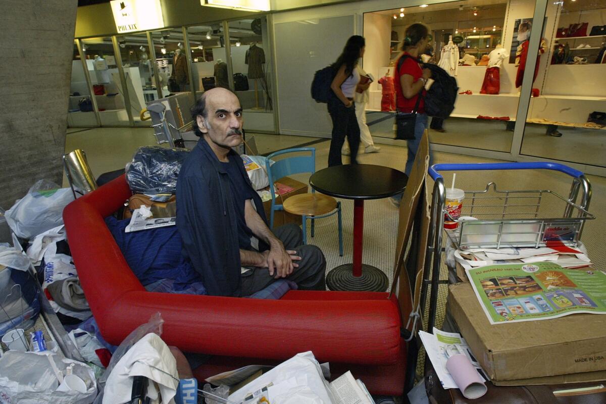 Merhan Karimi Nasseri sits among his belongings at Roissy Charles De Gaulle Airport.