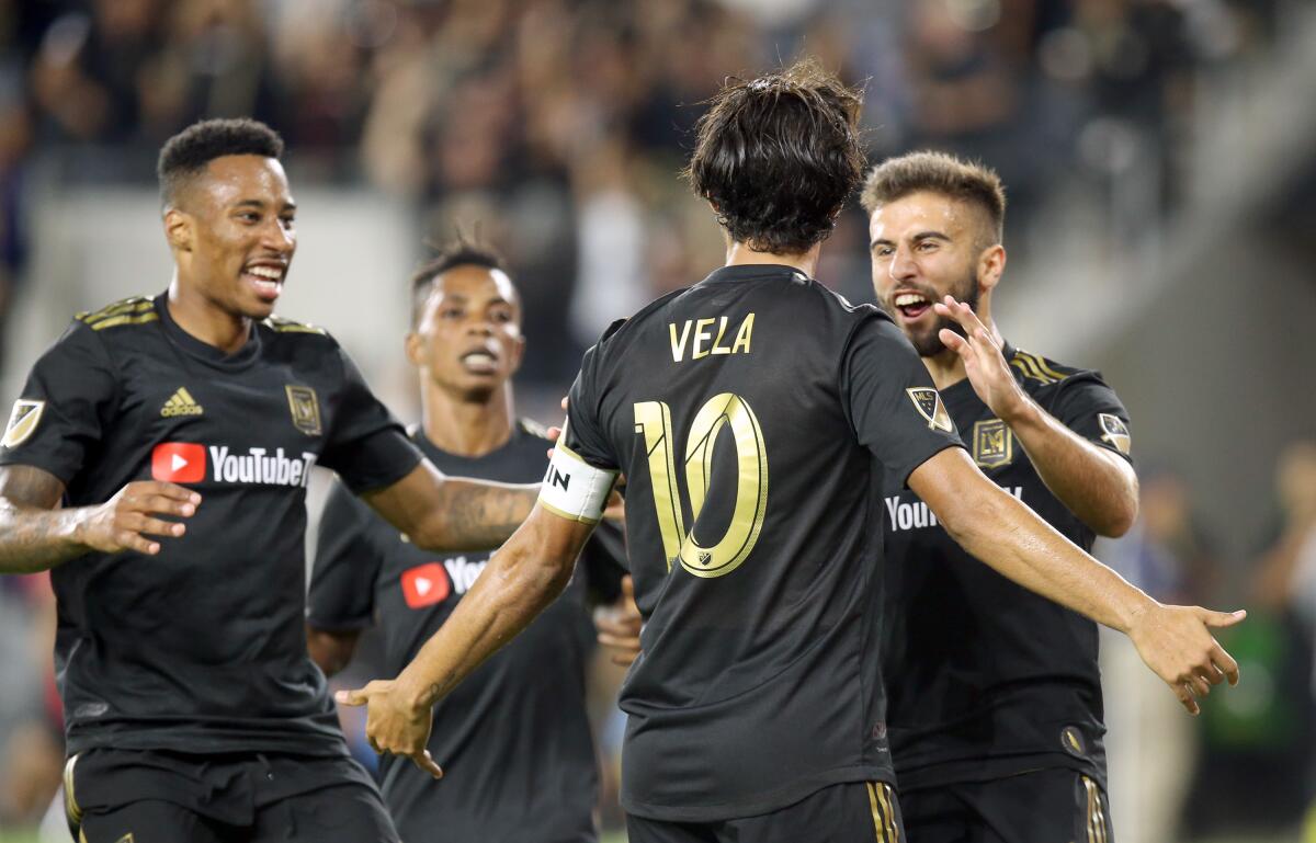 LAFC’s Carlos Vela celebrates with teammates after scoring during the second half of a 3-3 tie against the Galaxy on Sunday.