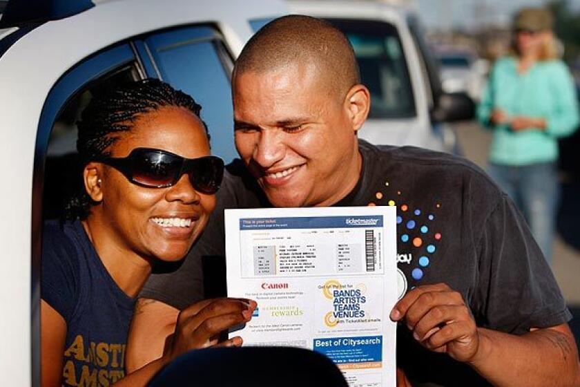 Michael Jackson fans Shaneese and Bob Lewis, of Palm Springs, show off the vouchers for tickets to the Jackson memorial that they won in an online lottery. The couple were among those lining up outside Dodger Stadium to get their tickets and wristbands to the Tuesday event. "I feel very lucky," said Bob Lewis, who won the tickets. "I learned to dance watching Michael Jackson."