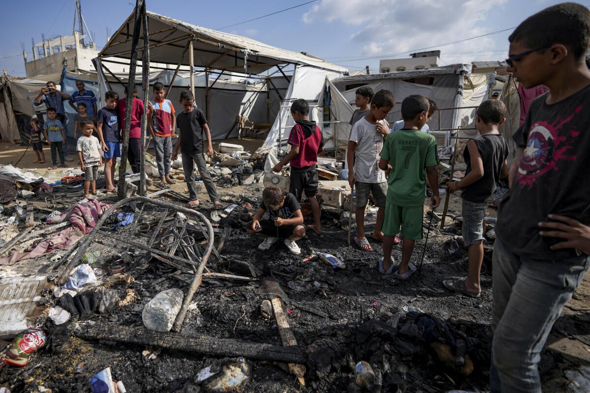 Palestinians inspect damage at a tent area in the courtyard of Al Aqsa Martyrs hospital, hit in an Israeli strike.