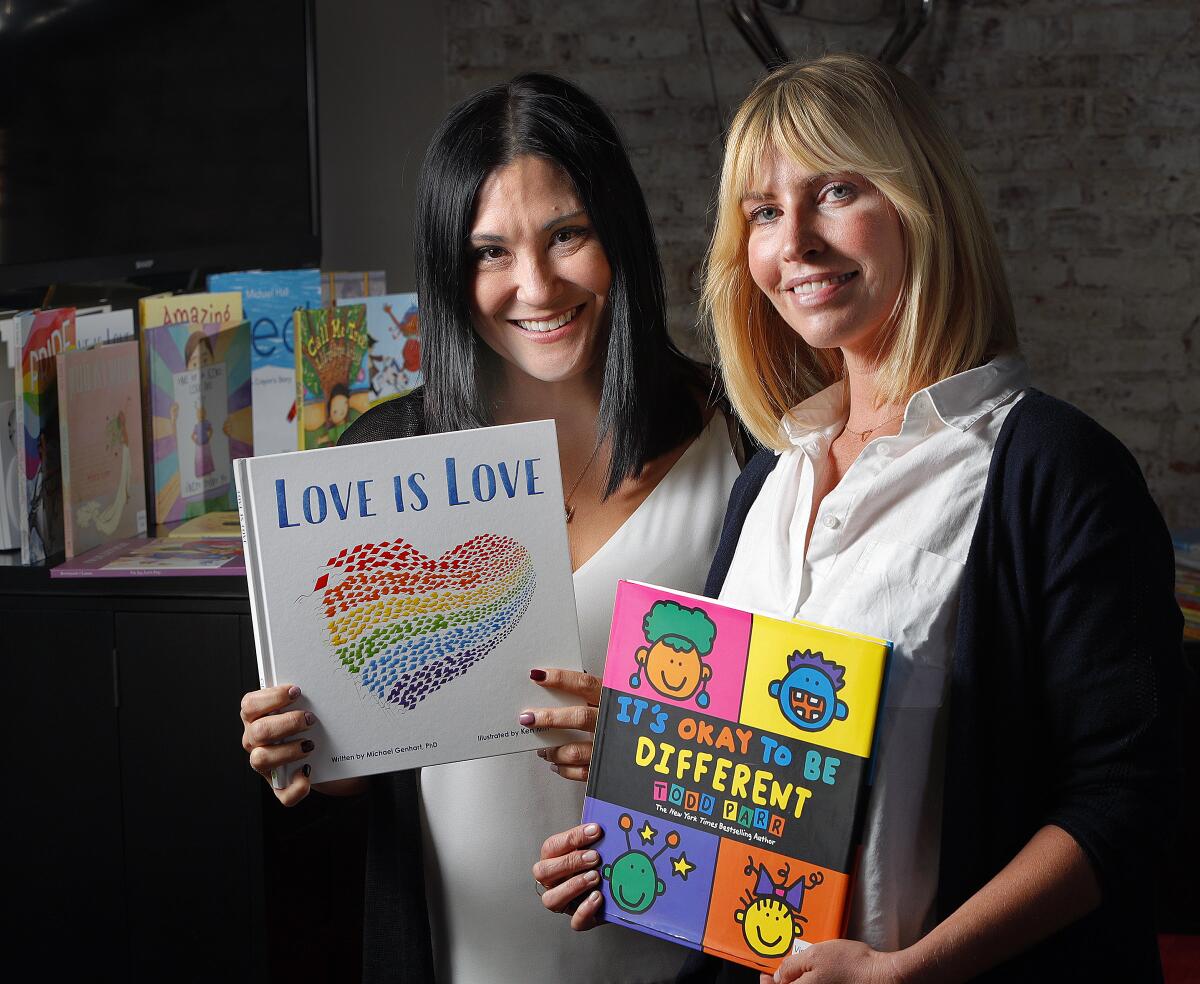 Gender Nation co-founders Keiko Feldman of La Crescenta and Morgan Walsh of Toluca Lake hold some of the LGBTQ-friendly books they are distributing through Juris Productions Inc. in Pasadena. The duo made a large donation to the Glendale Unified School District.