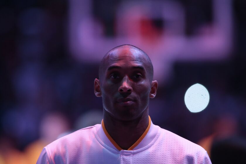Kobe Bryant stands for the national anthem before Sunday's game.