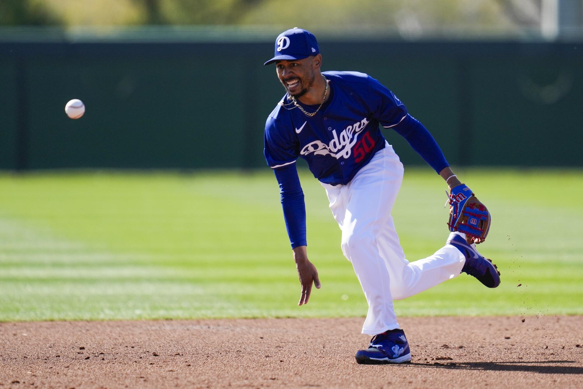 The Dodgers' Mookie Betts runs toward the ball during a spring training workout at Camelback Ranch in Phoenix on Feb. 14