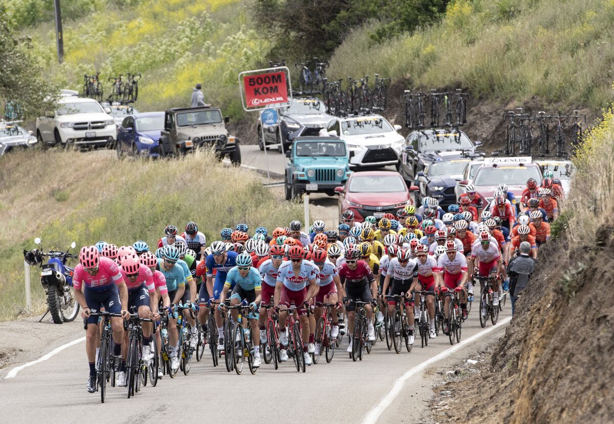 Taylor Phinney of the pink-shirted Education First team, leads the peloton up Patterson Pass in Livermore, Calif. Behind the cyclists are their team cars, where team directors discuss strategy via radio with their cyclists and mechanics can make on-the-spot bike repairs.
