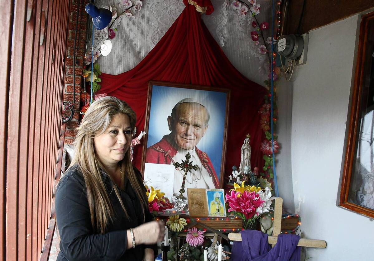 Costa Rica's Floribeth Mora stands by the shrine she made to Pope John Paul II at her. She suffered from a cerebral aneurysm that was inexplicably cured on May 1, 2011, the date of the late pope's beatification.
