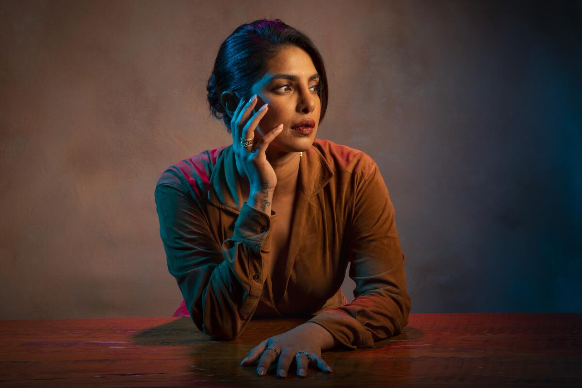 Priyanka Chopra Jonas, in profile, resting her chin in her upturned right palm