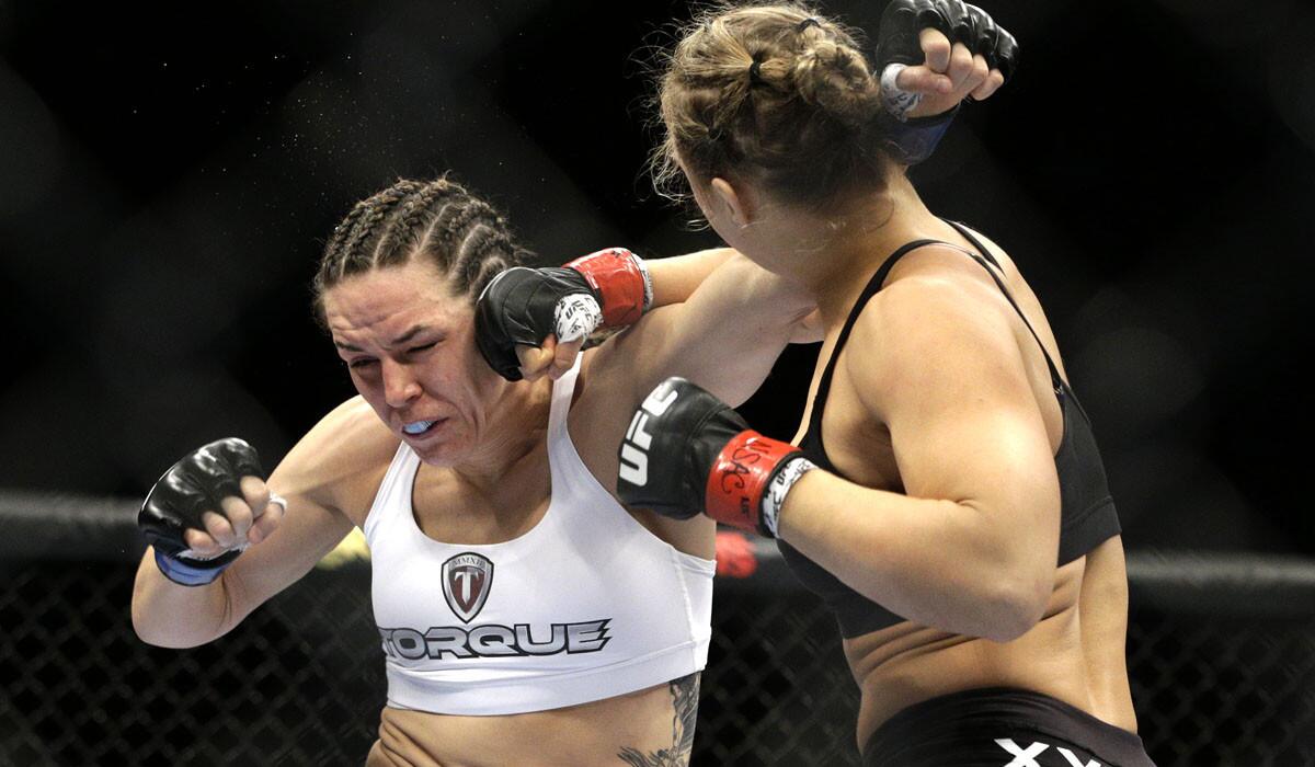 Ronda Rousey lands a punch against Alexis Davis during her UFC 175 victory.